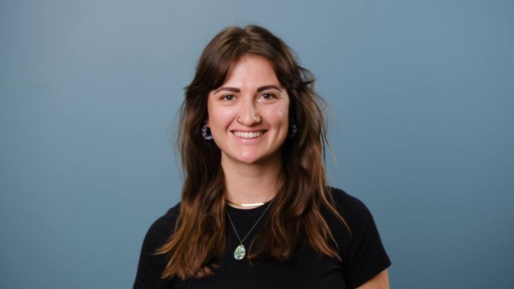 Annie smiling at the camera with a blue backdrop