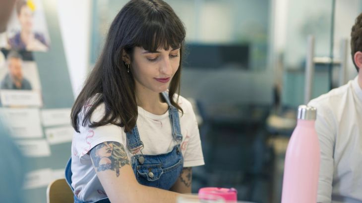 Elle sitting at a table thinking