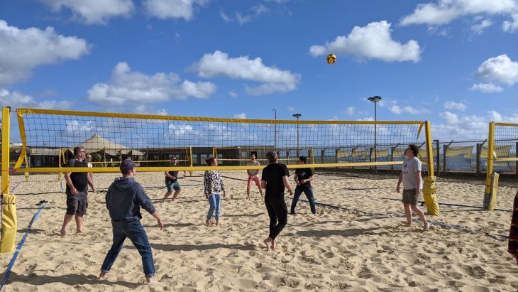 The Brightec team playing volleyball on the beach