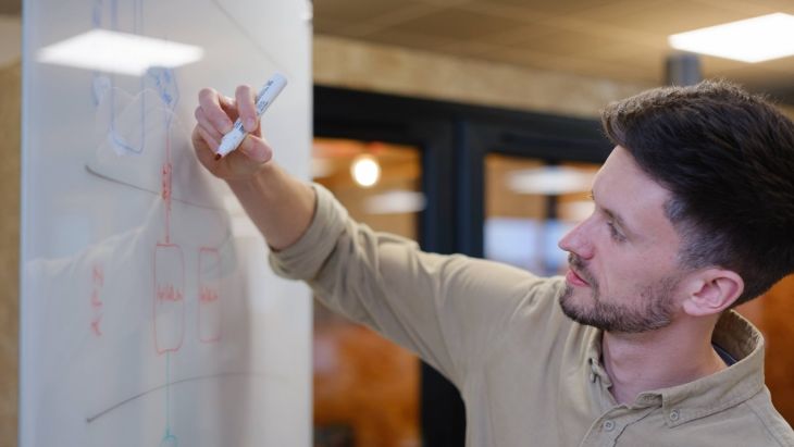Jonny writing notes on a whiteboard