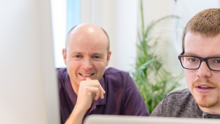 A photo of Nick and Alistair working at a desk together