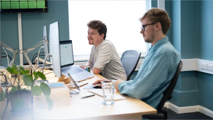 Alistair working at his desk alongside Rhys